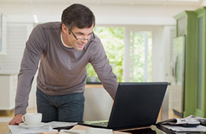 Man standing over laptop