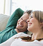 Couple smiling sitting on sofa